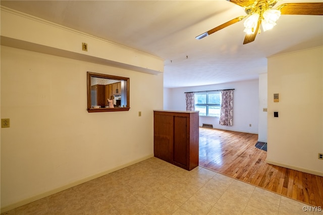 unfurnished room featuring ceiling fan, light wood-type flooring, and crown molding