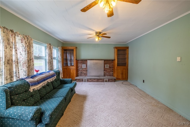 living room with ceiling fan, light colored carpet, a fireplace, and crown molding