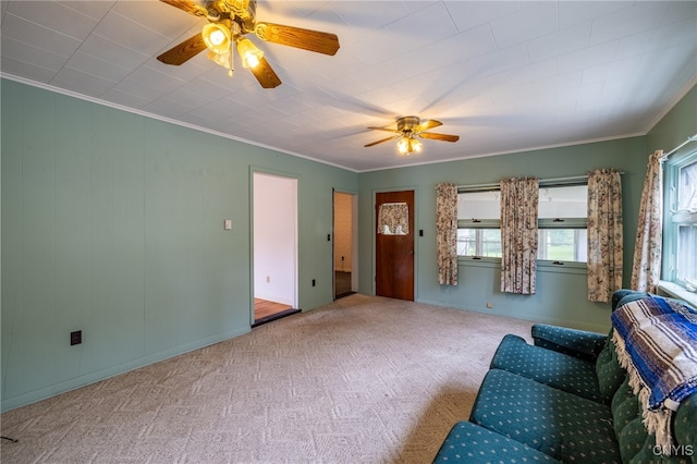 carpeted living room with crown molding and ceiling fan