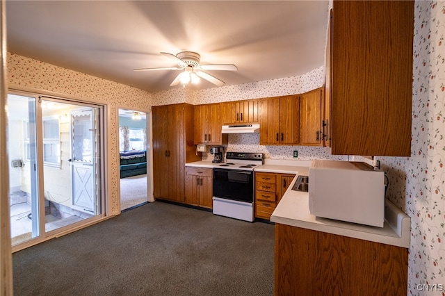 kitchen featuring a wealth of natural light, electric stove, ceiling fan, and dark colored carpet