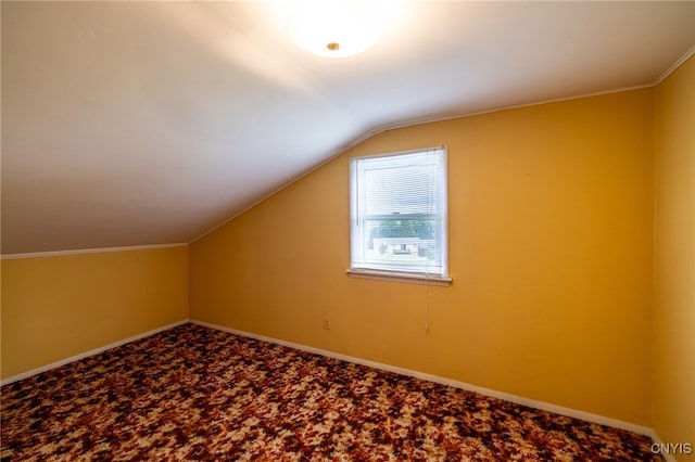 bonus room with vaulted ceiling and carpet flooring