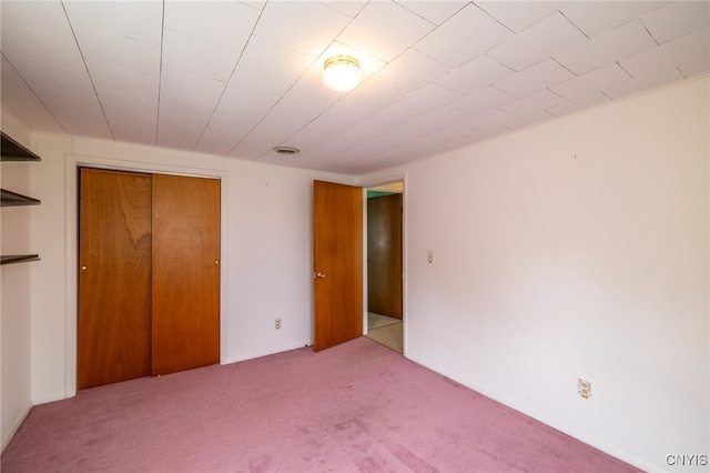 unfurnished bedroom with light carpet and a closet