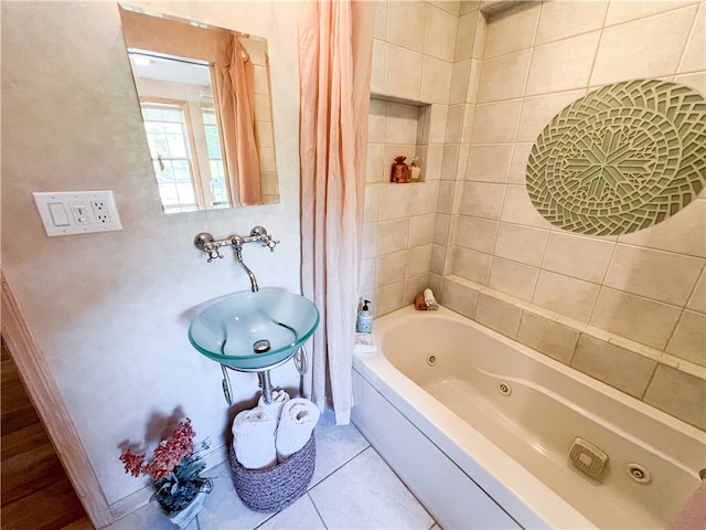 bathroom with a bathing tub, sink, and tile patterned floors