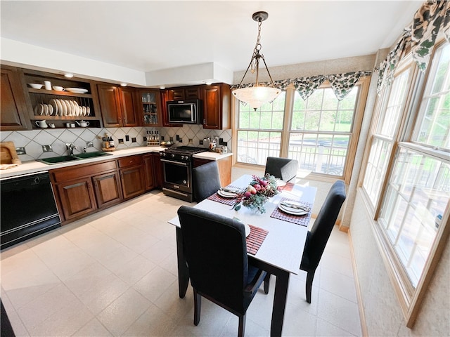 kitchen with black appliances, plenty of natural light, decorative light fixtures, and sink