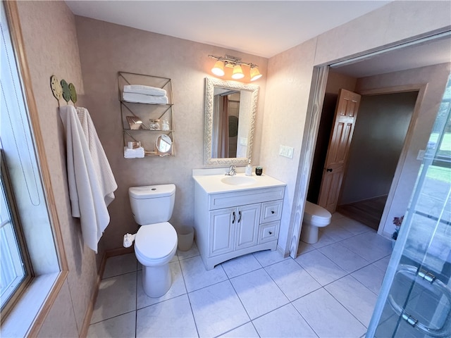 bathroom with walk in shower, vanity, tile patterned flooring, and toilet