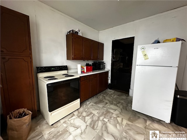 kitchen featuring dark brown cabinetry and white appliances