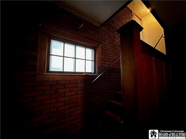 staircase featuring brick wall