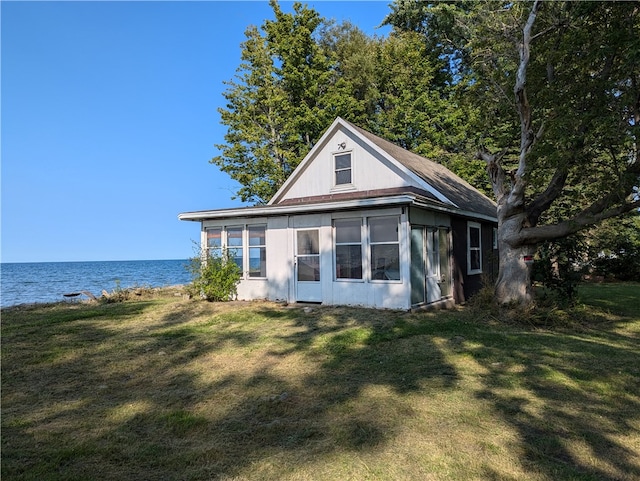 exterior space featuring a lawn and a water view