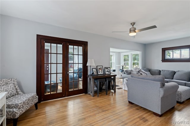 living room with ceiling fan, french doors, and light hardwood / wood-style floors