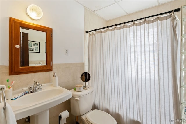 bathroom featuring toilet, a shower with shower curtain, and sink