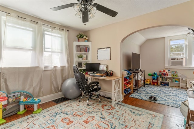 home office featuring a textured ceiling, hardwood / wood-style flooring, cooling unit, lofted ceiling, and ceiling fan