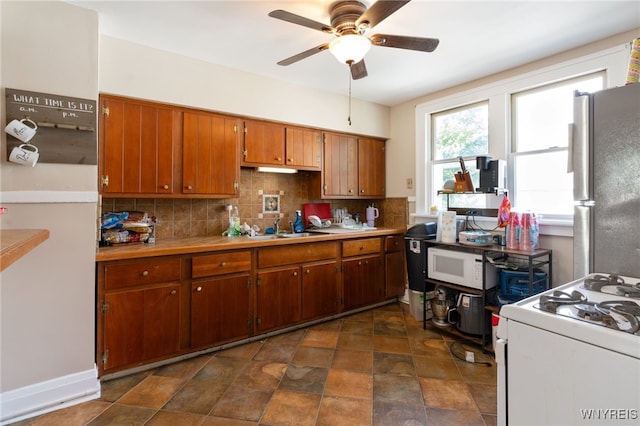 kitchen with ceiling fan, sink, tasteful backsplash, and white appliances