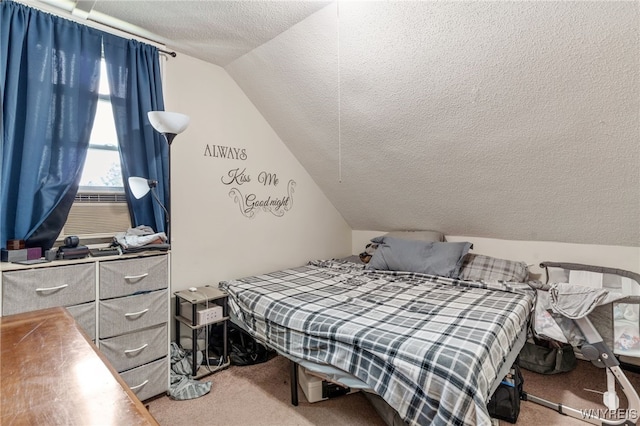 bedroom with carpet, vaulted ceiling, and a textured ceiling