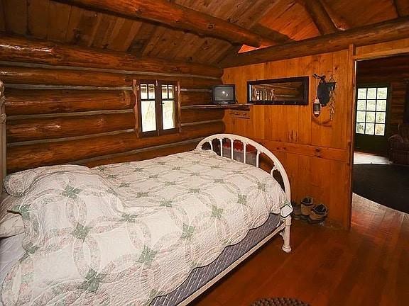 8578 County Road 49, Rushford, NY 14717 - bedroom with wood ceiling, log walls, wood finished floors, and wooden walls