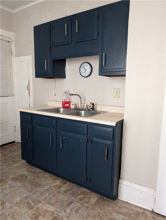 kitchen featuring ornamental molding, blue cabinetry, and sink