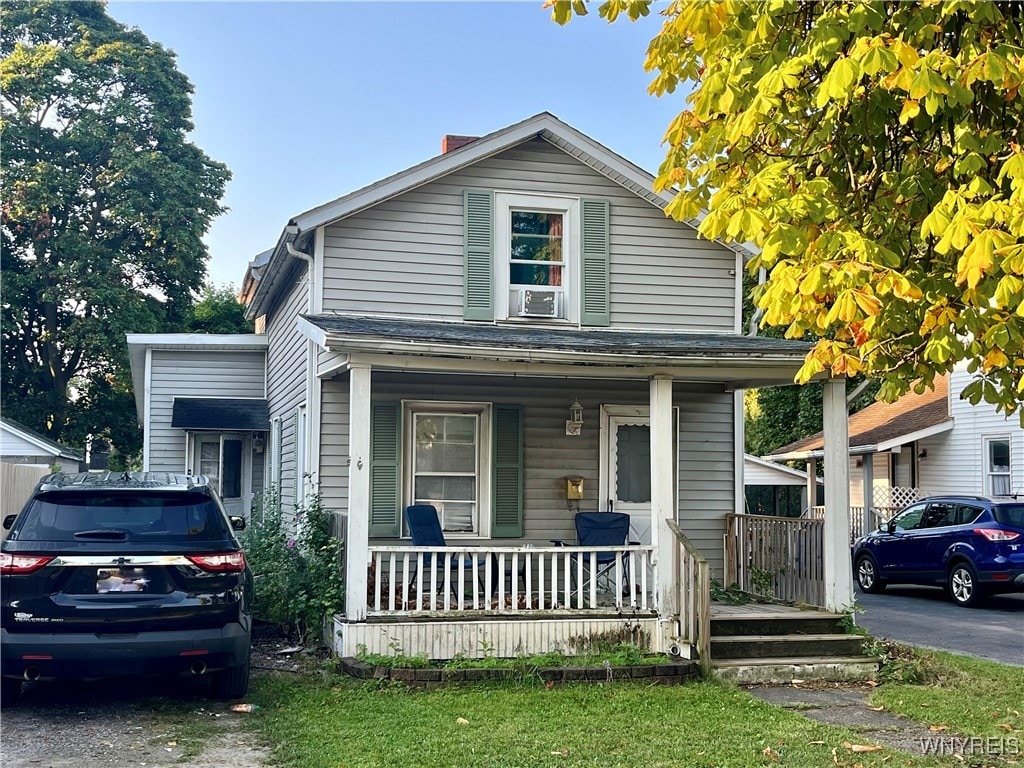 view of front of home with cooling unit and a porch