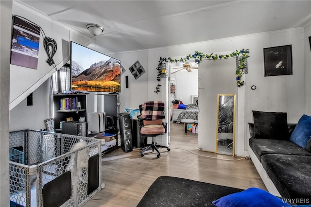 living room featuring ceiling fan, crown molding, and wood-type flooring