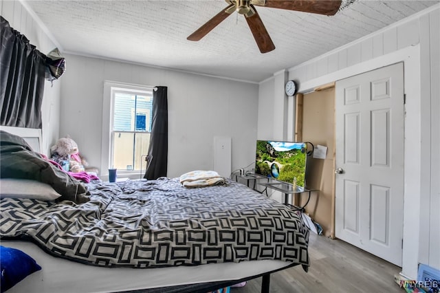 bedroom featuring ornamental molding, ceiling fan, and light hardwood / wood-style floors