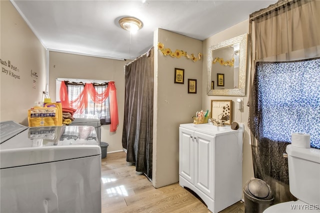 laundry room with washer and clothes dryer and light hardwood / wood-style floors