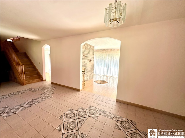 empty room featuring light wood-type flooring and a chandelier