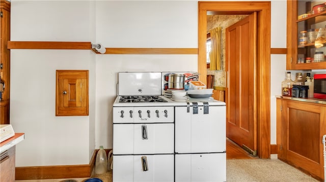 kitchen featuring light colored carpet and white gas stovetop