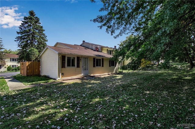 rear view of house featuring a lawn