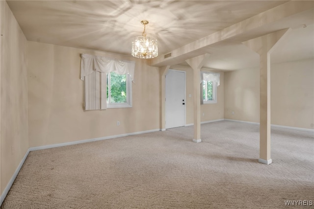 empty room featuring an inviting chandelier and light colored carpet