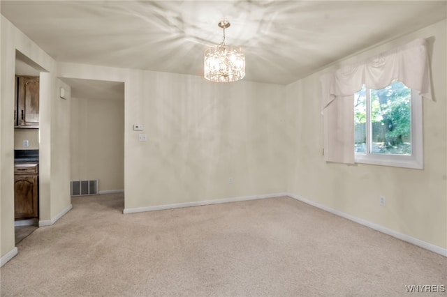 carpeted empty room with an inviting chandelier