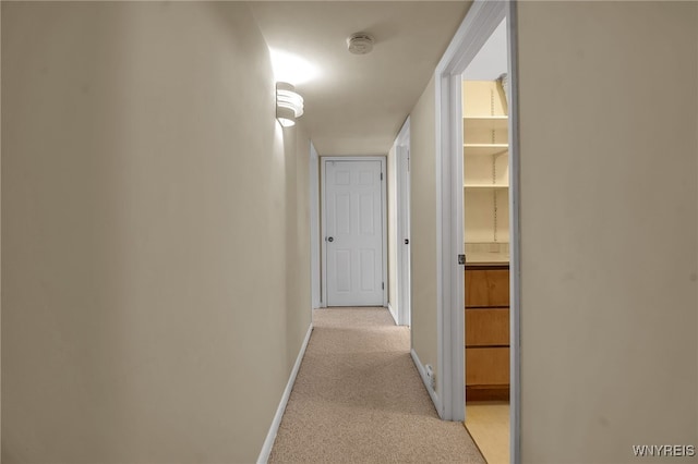 hall with light colored carpet