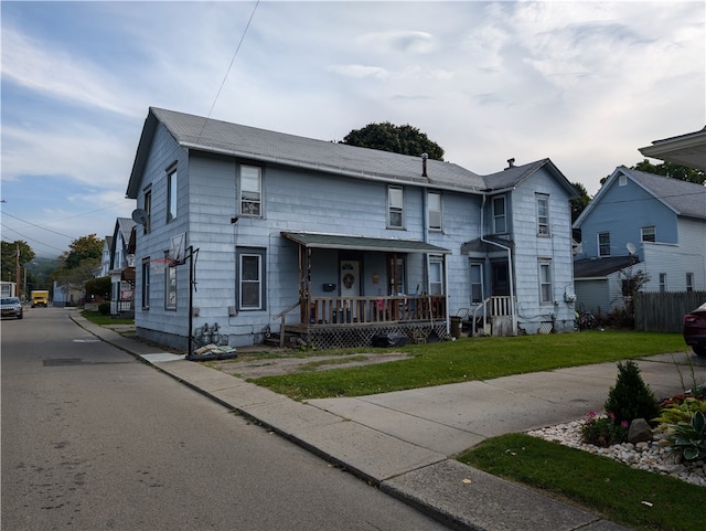 view of front of home with a front yard and covered porch