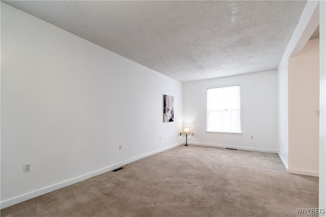 carpeted spare room featuring a textured ceiling