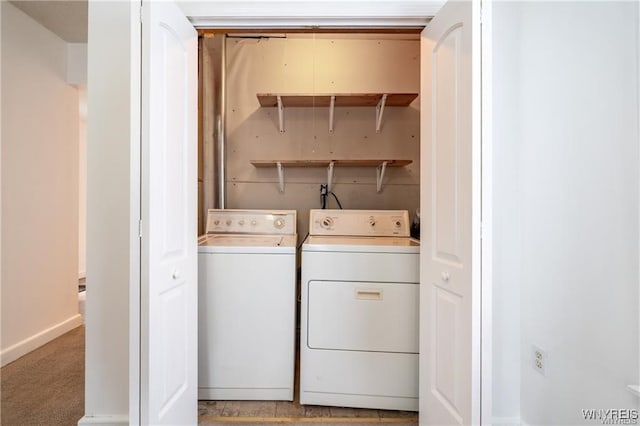 washroom with washing machine and dryer and carpet flooring