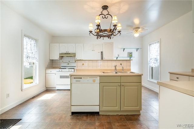 kitchen with pendant lighting, sink, white appliances, tasteful backsplash, and ceiling fan with notable chandelier