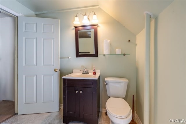 bathroom featuring vanity, vaulted ceiling, tile patterned floors, and toilet