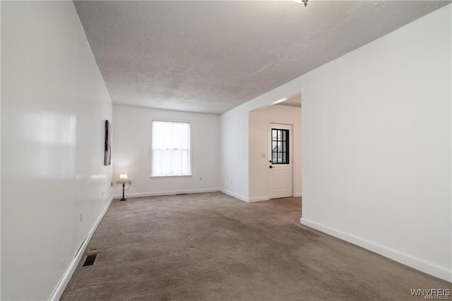 unfurnished room featuring carpet flooring and a textured ceiling