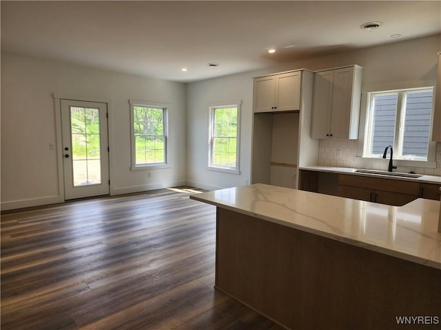 28 Glen Burn Trl, Ellicottville, NY 14731 - kitchen featuring a sink, dark wood-type flooring, light stone countertops, backsplash, and baseboards