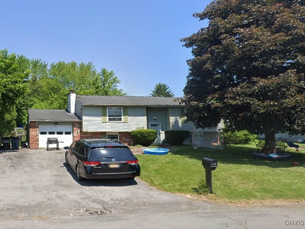 bi-level home with a garage and a front lawn