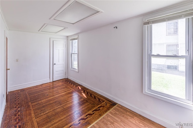 spare room with wood-type flooring and a healthy amount of sunlight