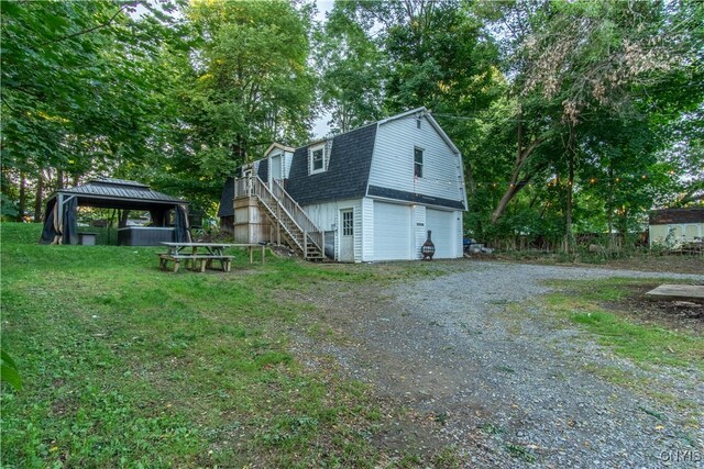 view of side of home featuring a lawn, a gazebo, and a garage