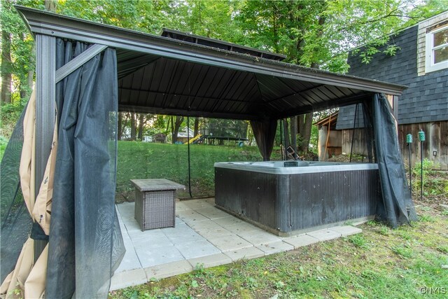 exterior space featuring a hot tub and a gazebo