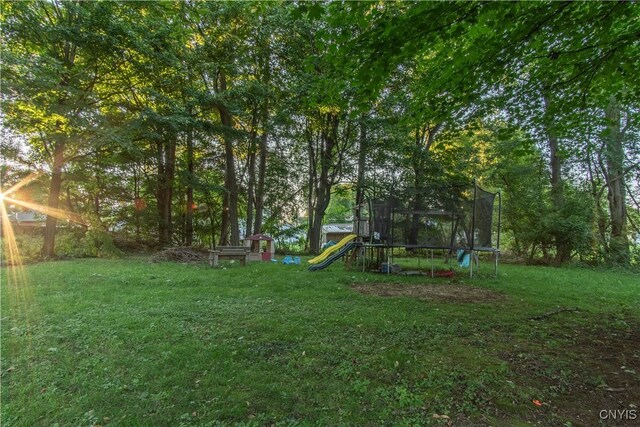 view of yard featuring a trampoline and a playground