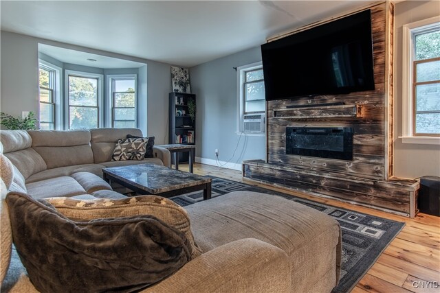 living room with cooling unit, hardwood / wood-style floors, and a wealth of natural light