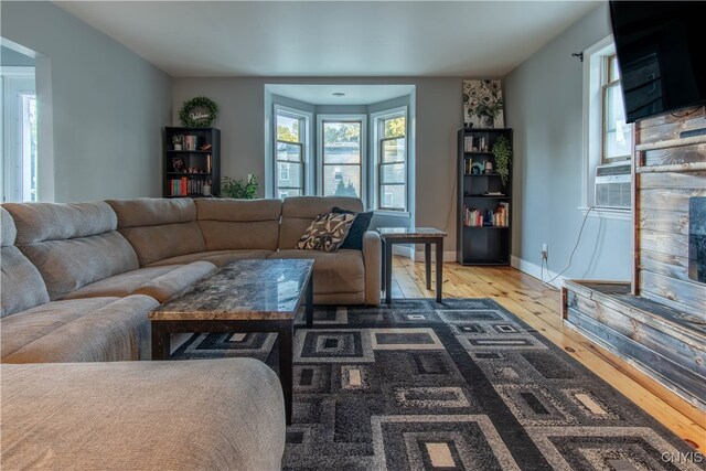 living room with wood-type flooring, a fireplace, and cooling unit