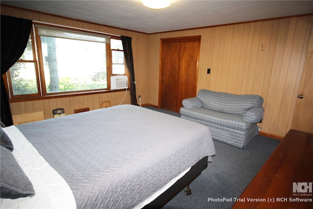 bedroom with cooling unit, wooden walls, a closet, and carpet