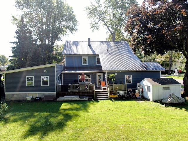 back of house with a storage unit, a wooden deck, and a yard