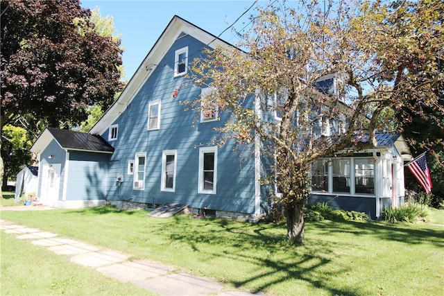 view of side of home with an outbuilding and a yard