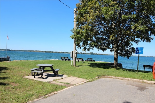 view of home's community with a water view and a yard