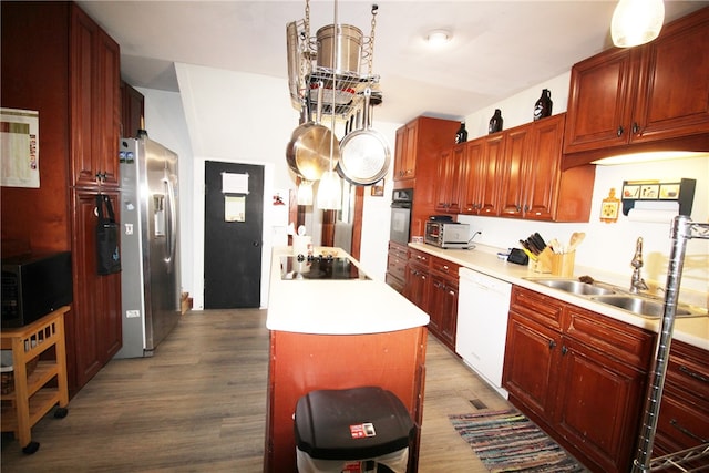 kitchen with hanging light fixtures, a kitchen island, black appliances, hardwood / wood-style flooring, and sink