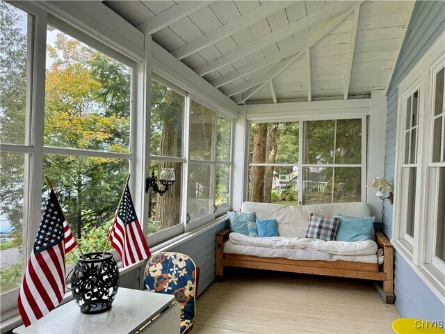 sunroom featuring wood ceiling, lofted ceiling with beams, and plenty of natural light