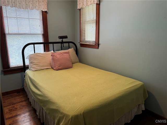 bedroom featuring multiple windows and dark wood-type flooring